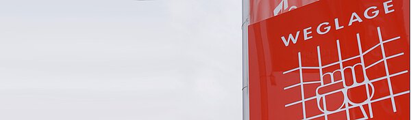 Weglage-Logo auf Pylon und Fahne im Hintergrund 